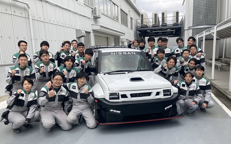KOTOを囲んで集合写真！日産京都自動車大学校の学生たち（学校指定のつなぎ姿）