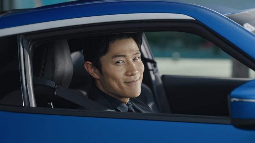 青い日産フェアレディZの運転席に座る鈴木 亮平のCM「心にグッッッッッっとくるクルマ」篇の一場面