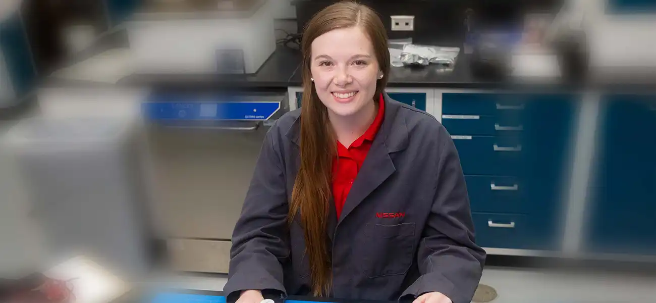 A portrait of Tori Keerl in her dark gray Nissan coat at her desk.