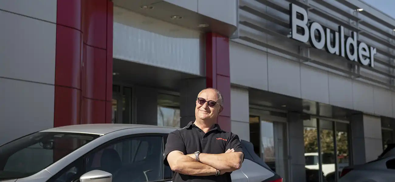 A man pausing in front of a Boulder building.