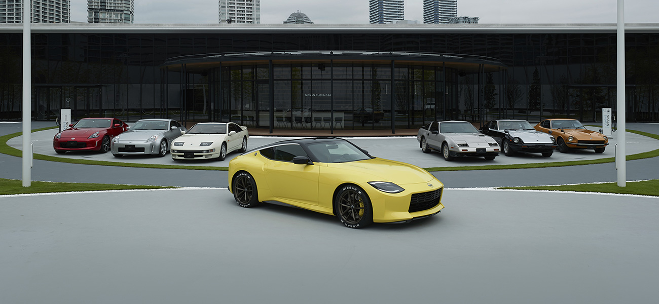 7 Nissan Zs parked in front of a building featuring the yellow Z in the front center.