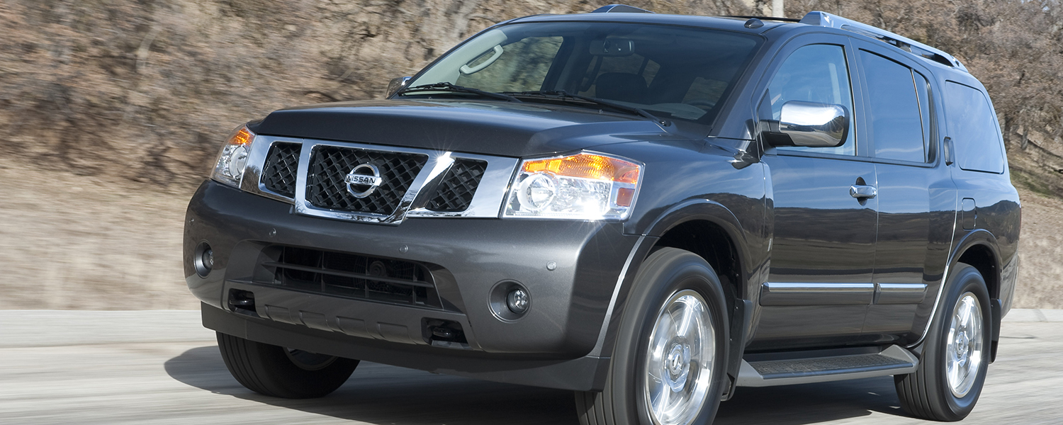 A black Nissan Armada driving up a dirt road on an incline.