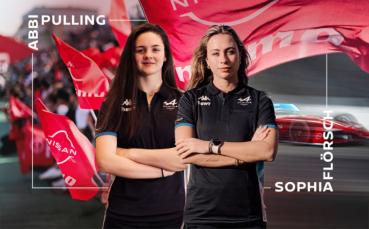 女性ドライバー、アビー プリング（左）とソフィア フルーシュ（右）。赤いNISMOフラッグとフォーミュラEマシンを背景に、両者ともアルピーヌ・アカデミーのウエア姿で腕組み。