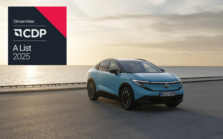 A turquoise Nissan LEAF electric vehicle is parked along a scenic coastal road, with the calm sea and a glowing sunset stretching across the horizon. In the top-left corner, the CDP logo appears, highlighting its highest “A List” rating for Climate Change and Water Security.