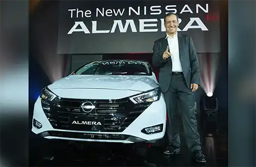 A photo of Nissan Philippines President Juan Manuel Hoyos standing on the side of the New Almera with NissanConnect Services