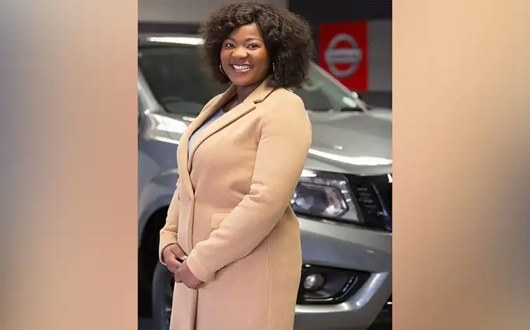 Chantelle Nkosi posing in front of a nissan vehicle with her hands crossed.