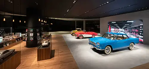 Three vintage cars in indoor exhibit