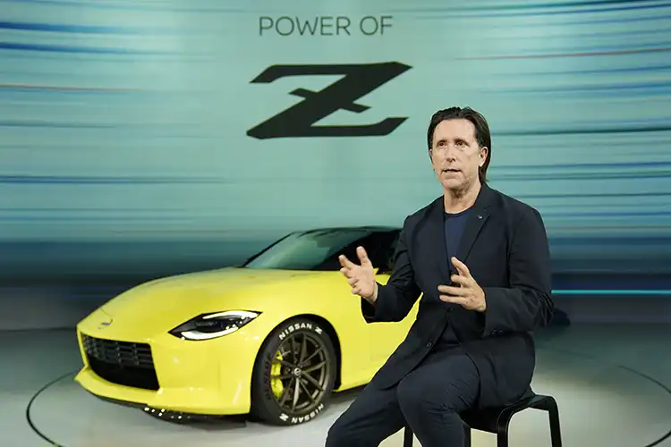 Alfonso Albaisa sentado delante de un Nissan Z amarillo