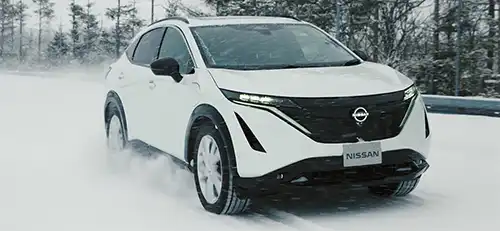 White vehicle driving through snow