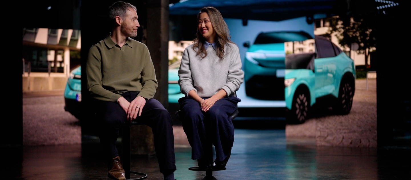 Chris Ramsey sitting on a chair to the left and Julie Ramsey on the right with a blue Nissan

LEAF behind them
