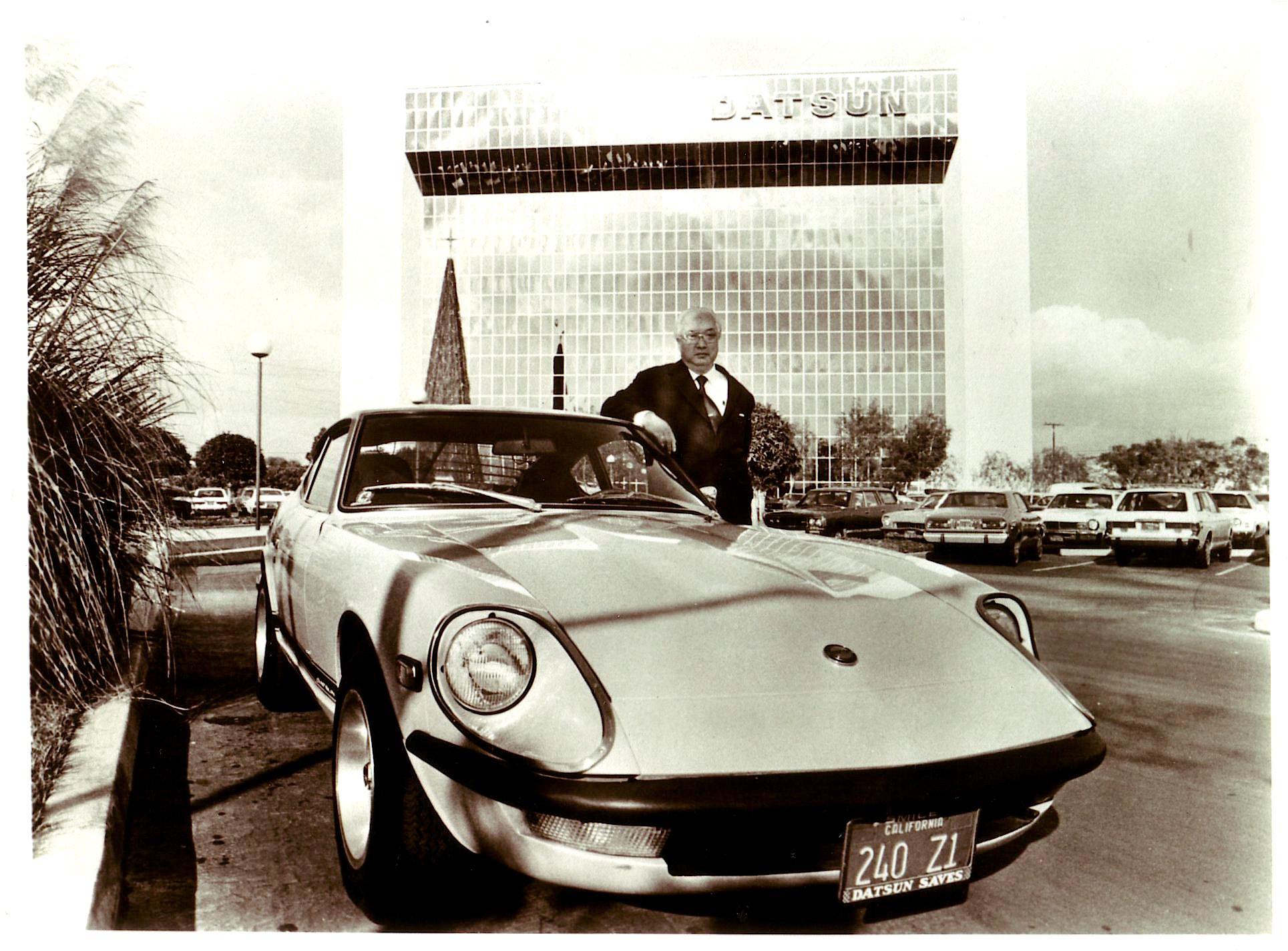 Vintage picture of the Nissan legend Yutaka Katayama standing next to classic Nissan Z