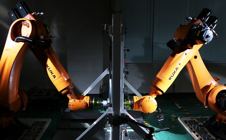 棒状の工具を取り付けたロボットが、パネルを徐々に変形させて成形する「インクリメンタル成形」技術「対向式ダイレス成形」