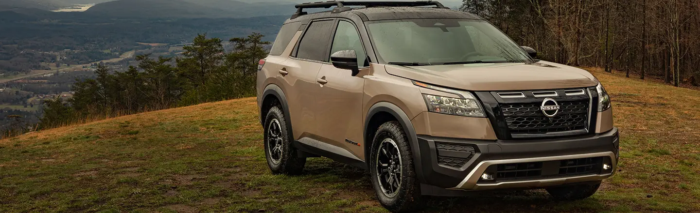 Nissan Pathfinder on a hill with cloudy weather.