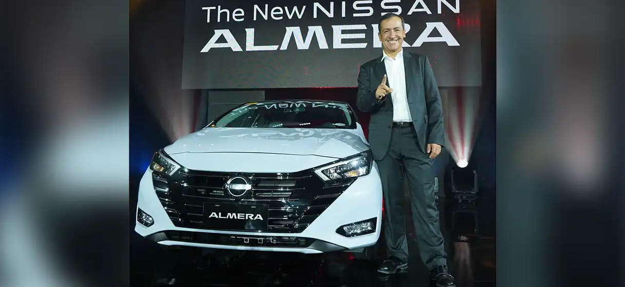 A photo of Nissan Philippines President Juan Manuel Hoyos standing on the side of the New Almera with NissanConnect Services