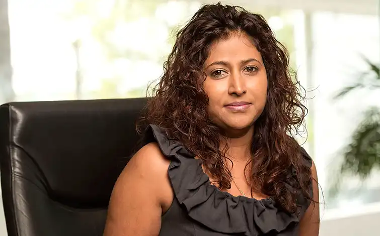 Nancy Moodley posing for a photo while sitting in a chair