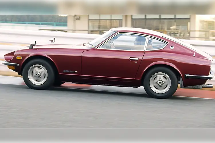 A side shot of a red Nissan Z driving on the road