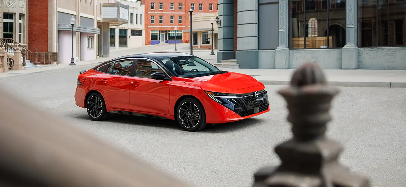 Front right 3/4 view of the 2026 Nissan Sentra driving on a city pathway.