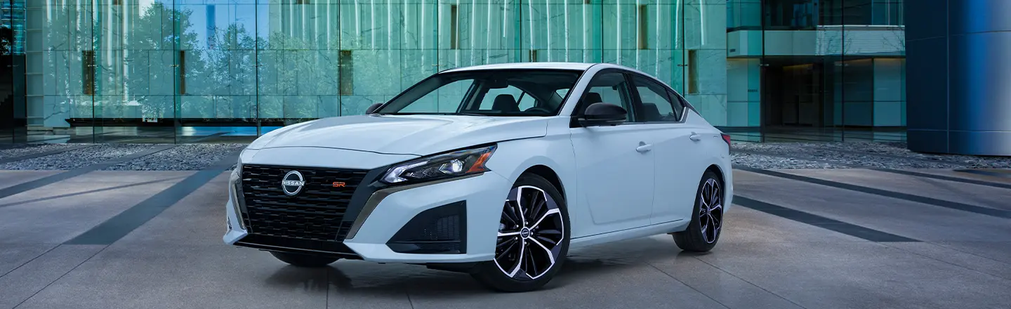 Front left view of the 2023 Nissan Altima parked in front of a building.