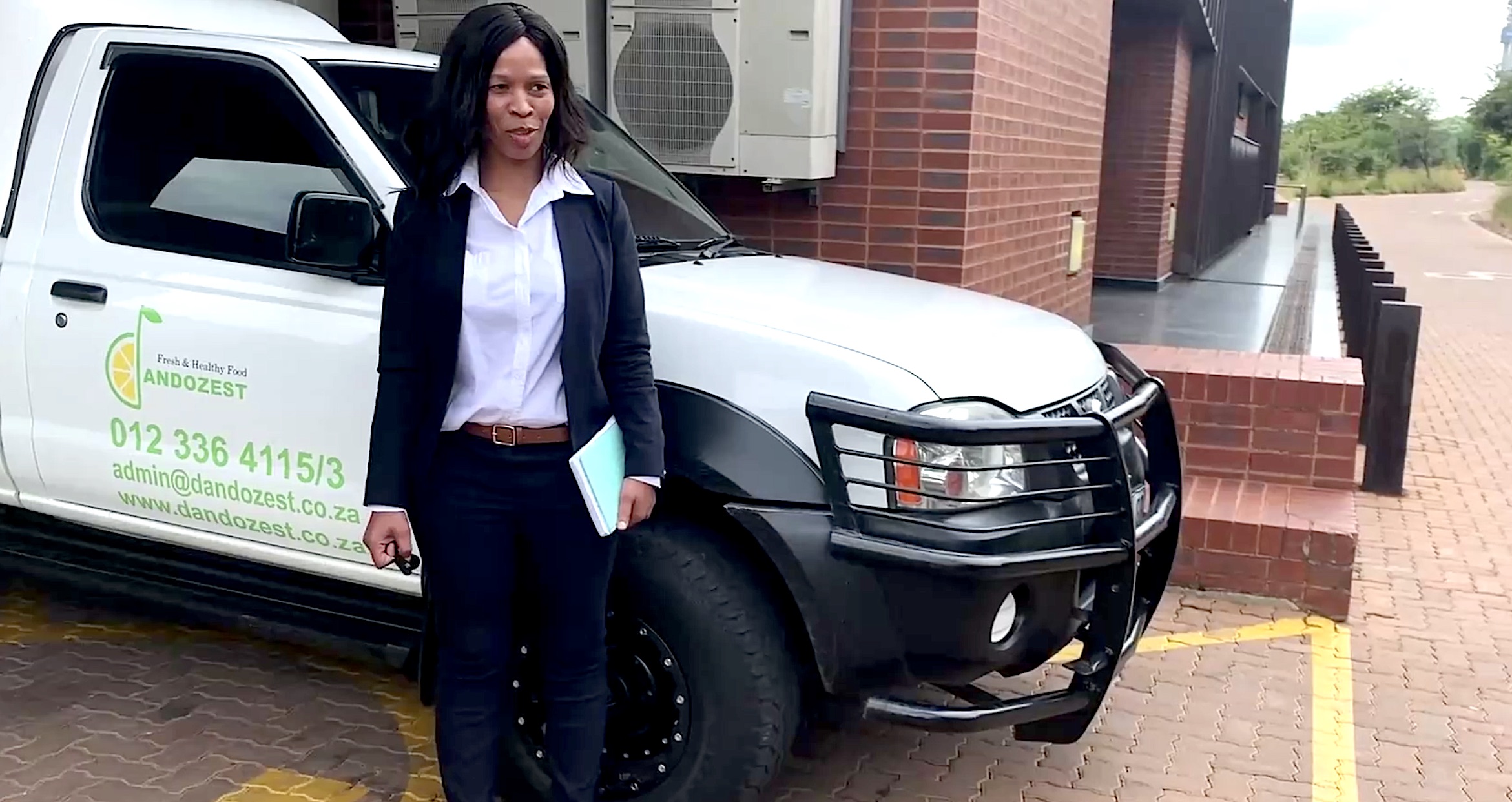 Nontuthuko Constance Shandu posing for a photo in front of a truck