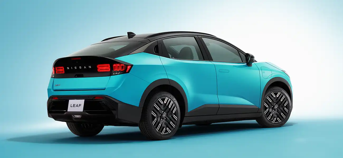 Rear 3/4 view of the 2026 Nissan LEAF against a blue background.
