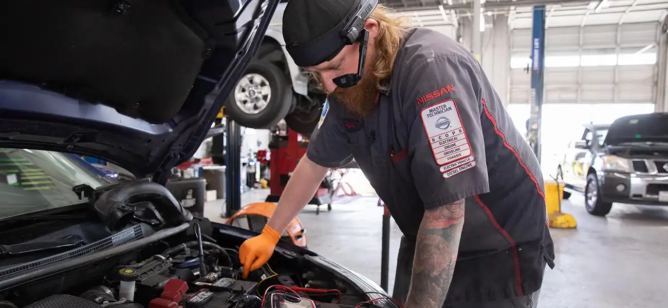 Skyler Petrille, Nissan master technician working on a car with the wearable technology on his head.
