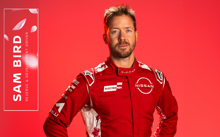 Landscape graphic photo of Nissan Formula E Team Reserve and Development Driver Sam Bird standing with his hands on his hips in the red team race suit in front of a red background with a label naming him and his role in white on the left-hand side.