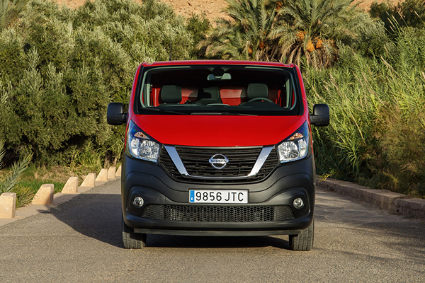 A red colored Nissan vehicle facing forward in a rocky background