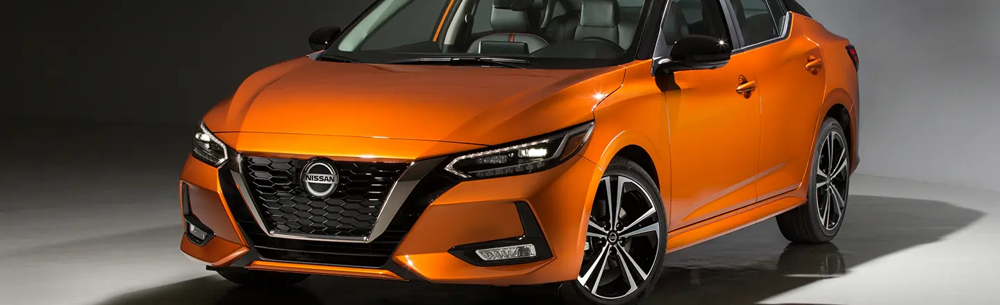 Front right driver side angle view of an orange Nissan Versa