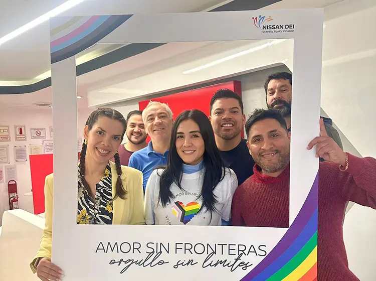 Um grupo de funcionários da Nissan segurando uma moldura que diz “Amor sem fronteras, orgulho sem limites”
