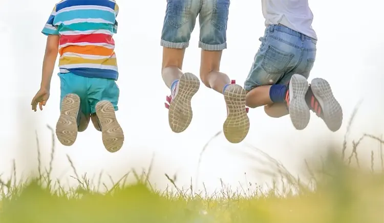 Kids jumping in grass