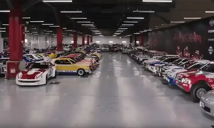 Nissan’s iconic cars throughout the past eight decades displayed in a large room.
