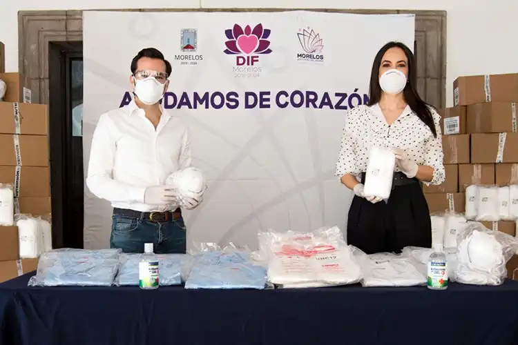 dos personas con mascarilla sosteniendo mascarillas