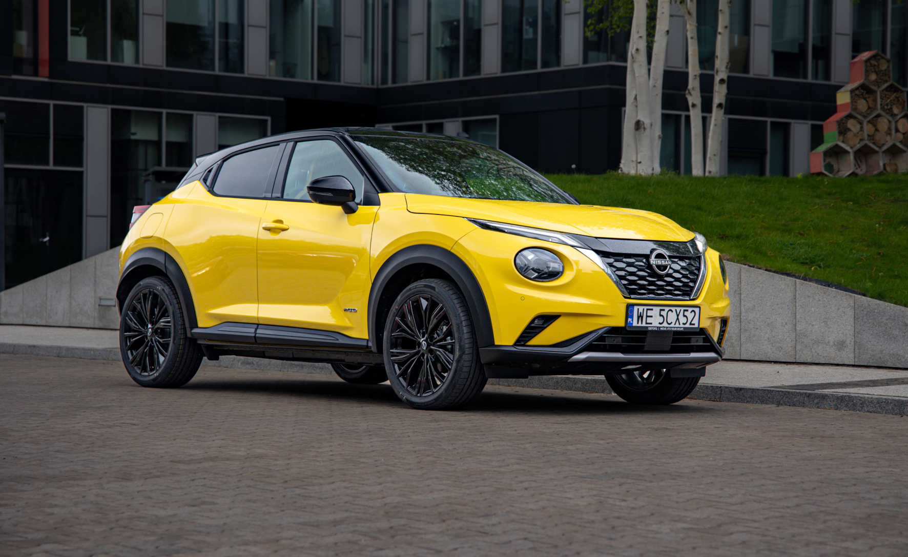 Żółty Nissan Juke stojący przed budynkiem