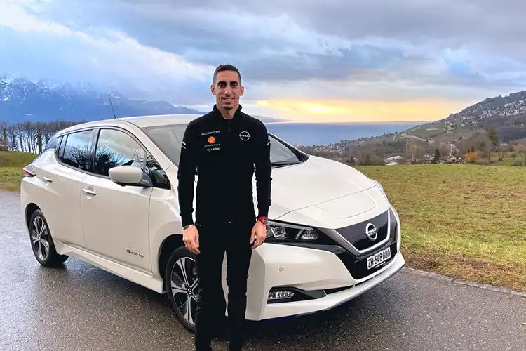 Sébastien Buemi delante de un Nissan LEAF blanco.