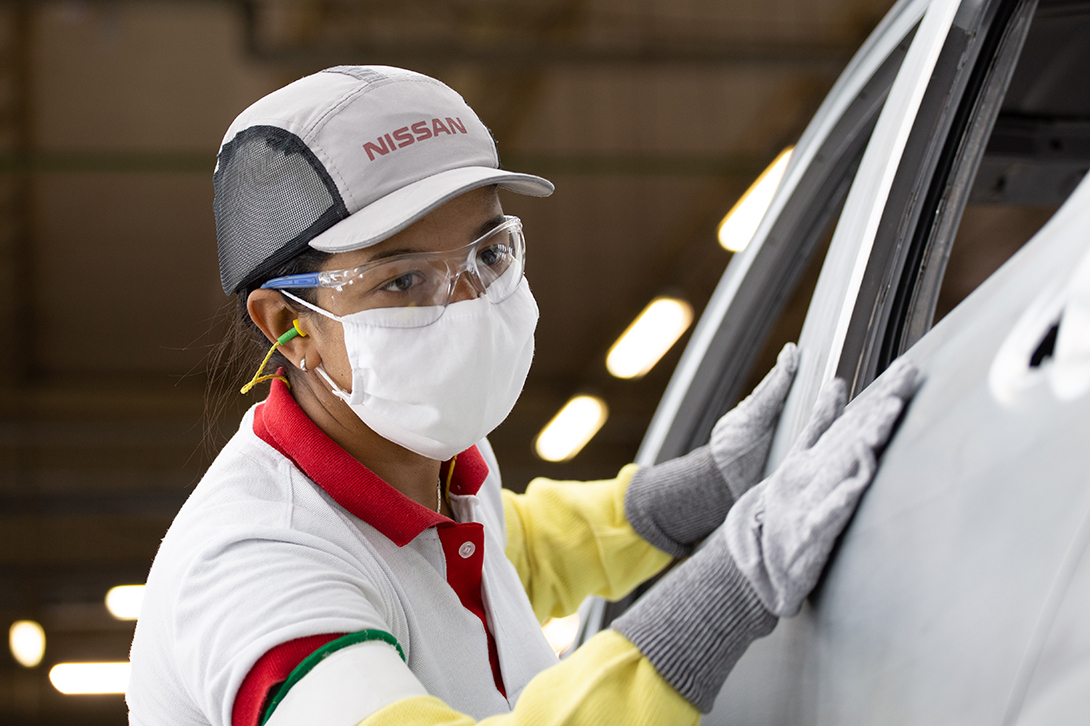 Uma pessoa verificando um carro na linha de montagem