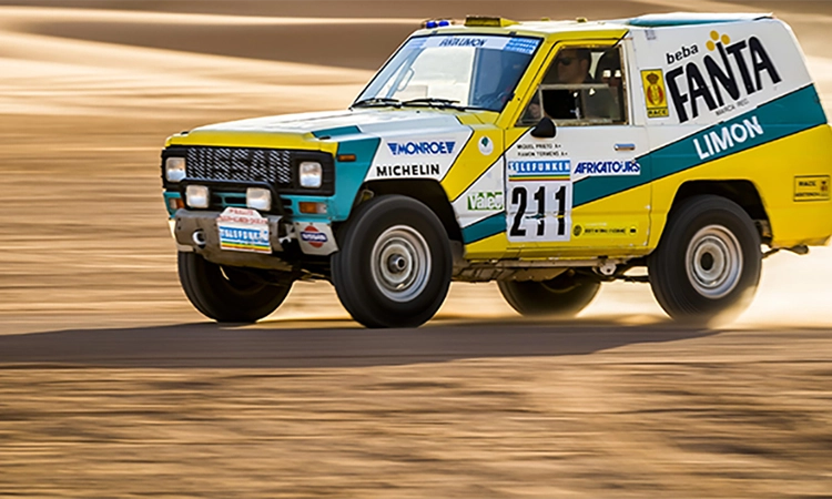 1987 Paris-Dakar rally car driving in the desert.