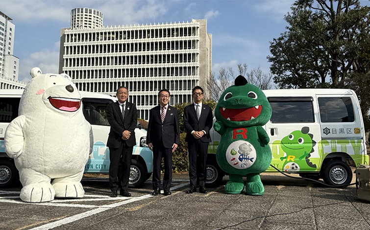 電気自動車の前で記念撮影する各代表者
