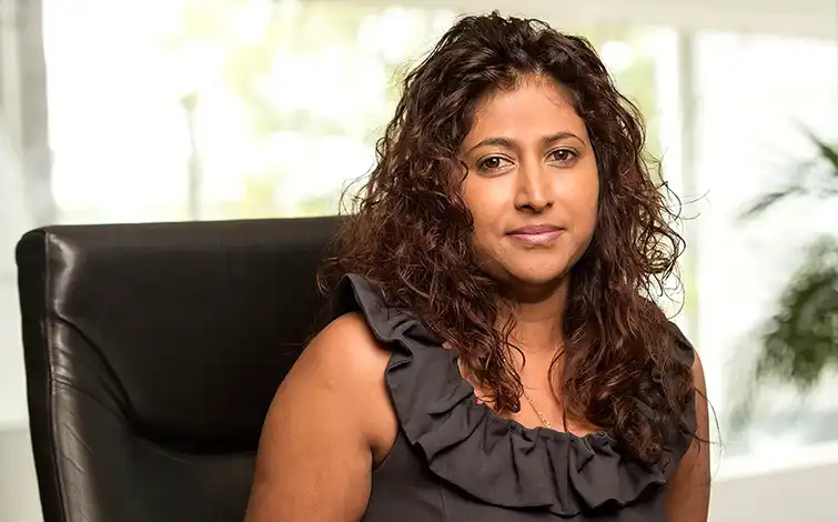 Nancy Moodley sitting in a chair posing for a photo