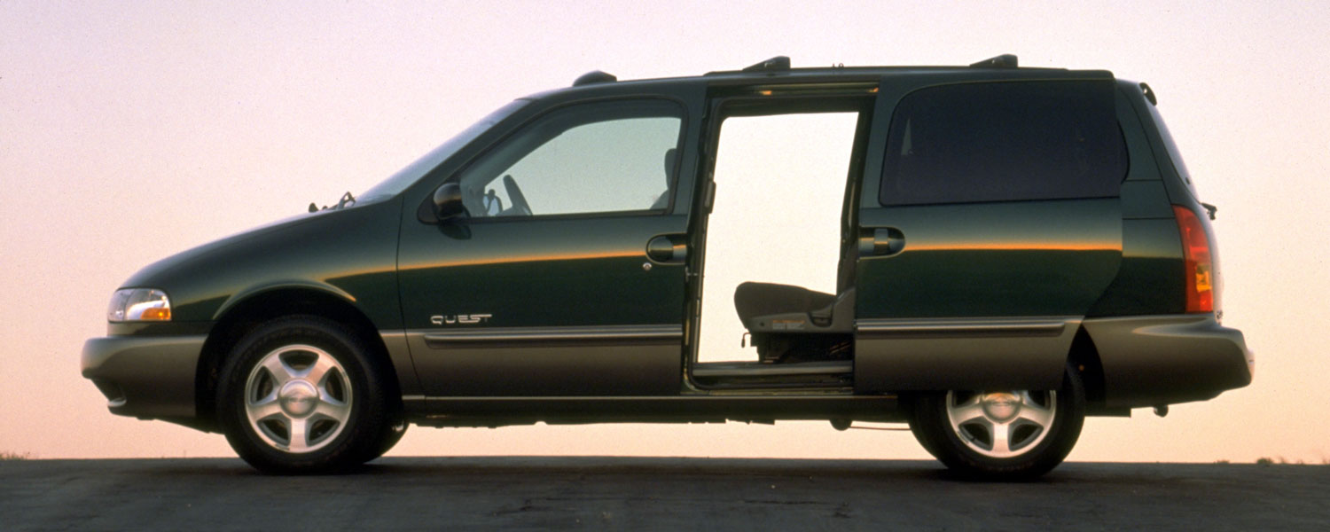 A dark green Nissan Quest parked on an empty road with both side doors opened with the sun shinning through.