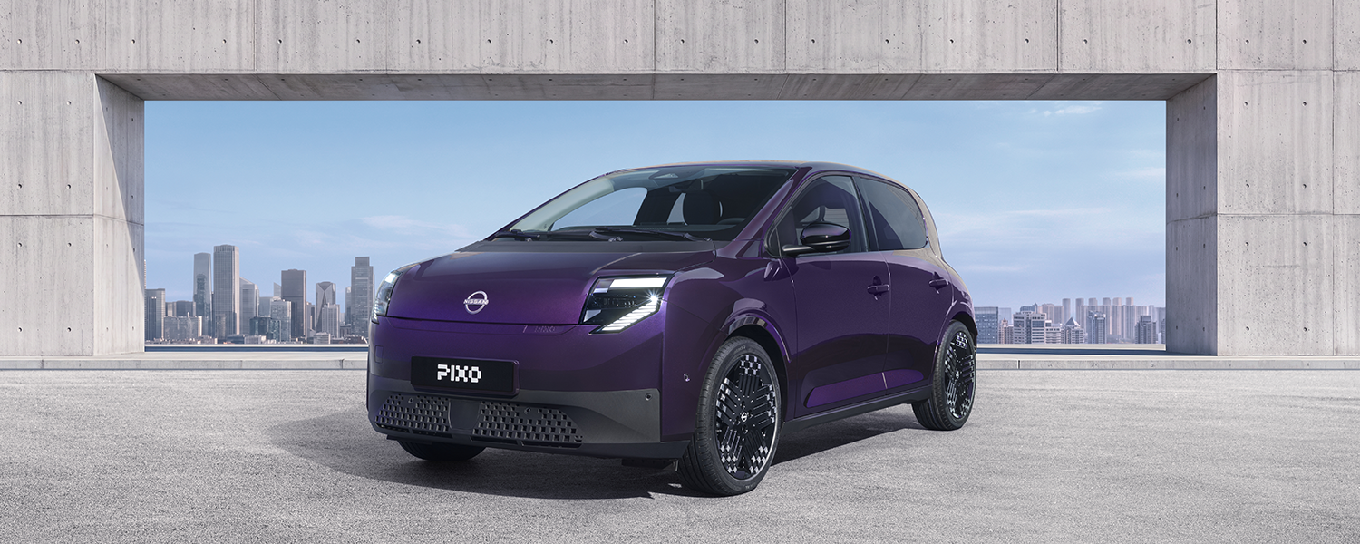 Three-quarter front view of a purple Nissan PIXO electric city car parked beneath a modern concrete structure, with a city skyline in the background.