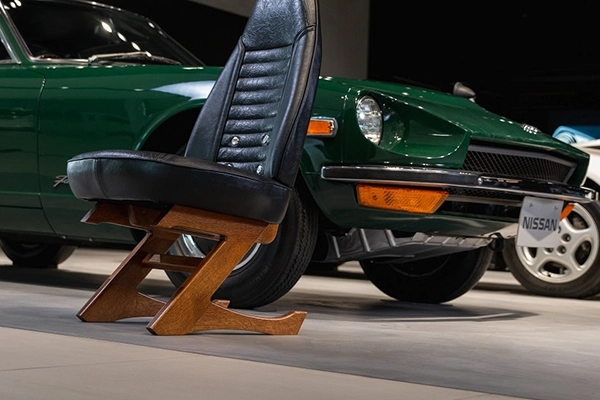 An image of a green Nissan car and a black Nissan Z chair.