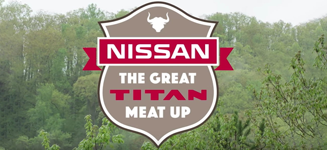 An image with a logo of Nissan the great Titan meat up with a green forest in the background.