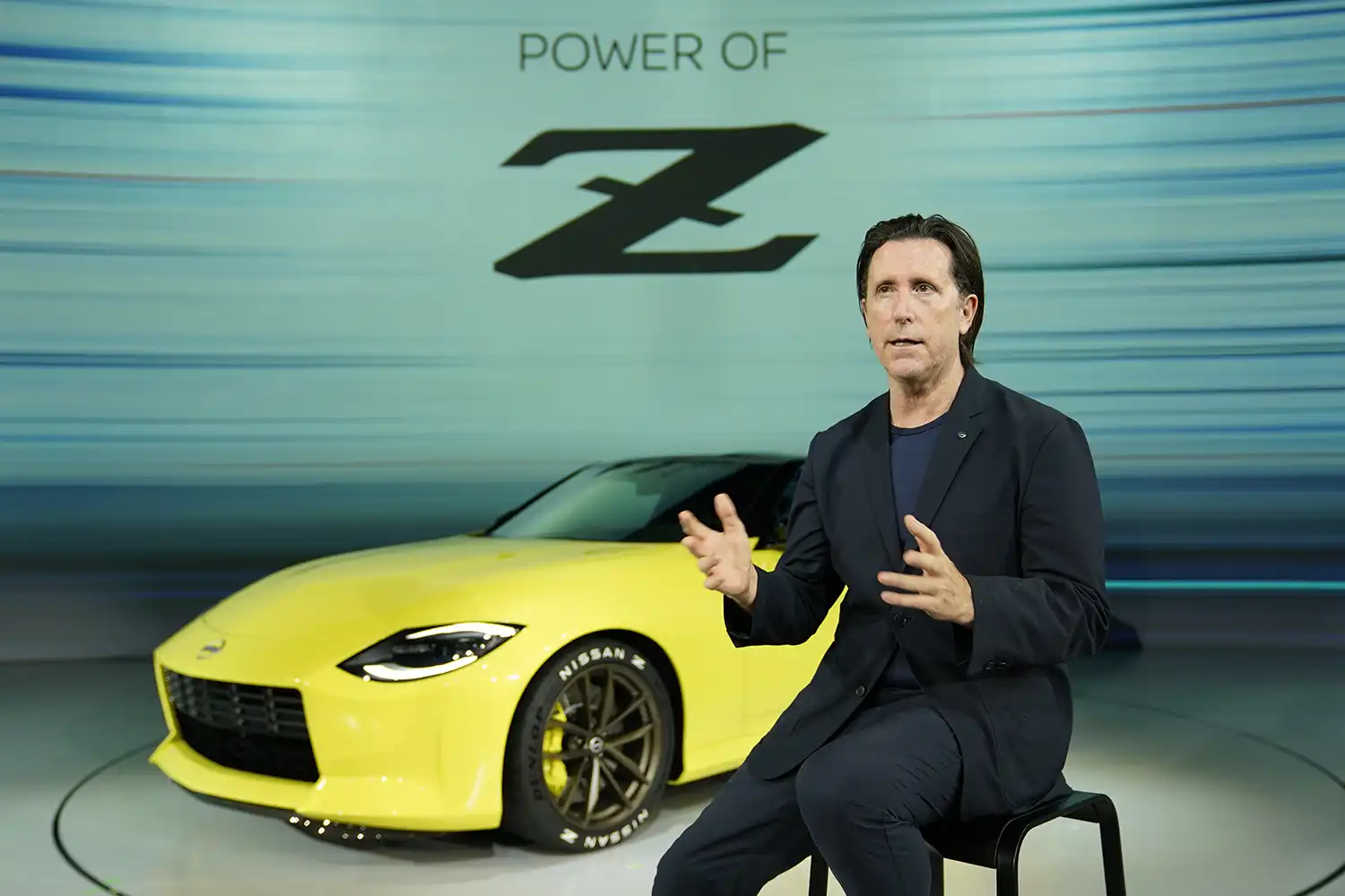 Alfonso Albaisa sentado delante de un Nissan Z amarillo
