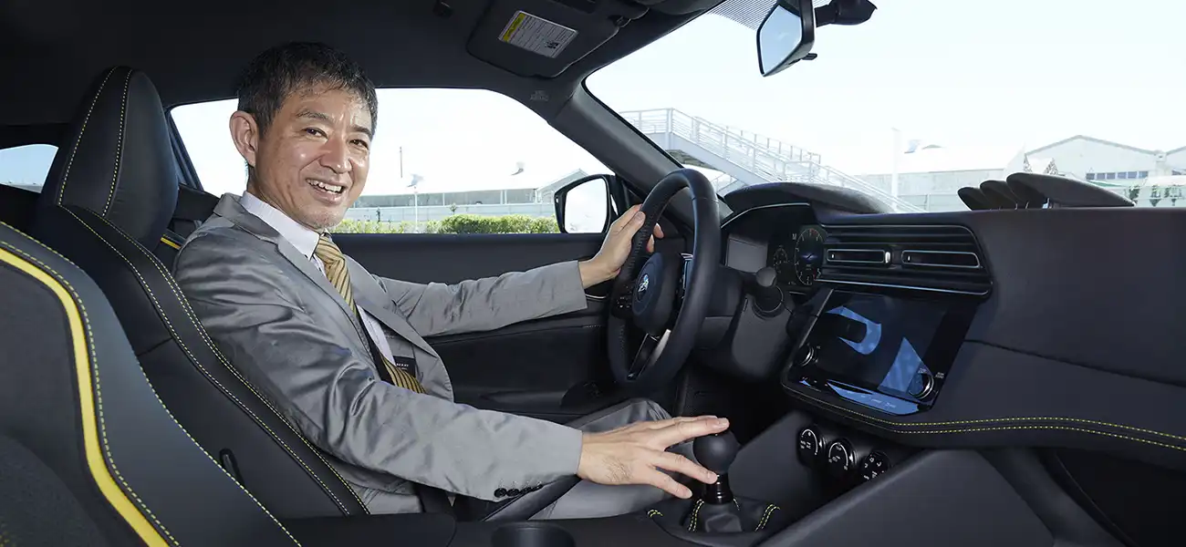 Hiroshi Tamura sitting in the driver seat of a Nissan Z.