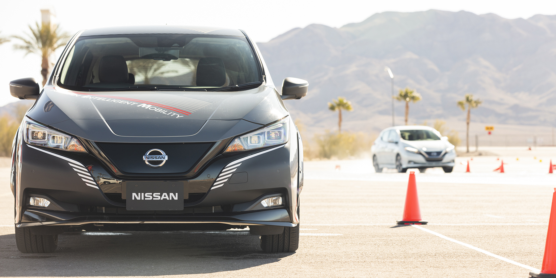 Un coche Nissan aparcado junto a conos rojos.