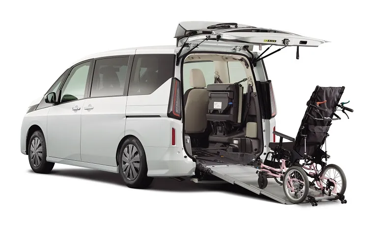 白いセレナ_チェアキャブ_スロープタイプの車いす乗降用スロープを車両後部から展開し、左斜め後ろから撮影した商品イメージ