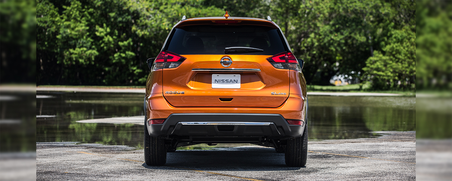 Rear angle photo of an orange Nissan Rogue