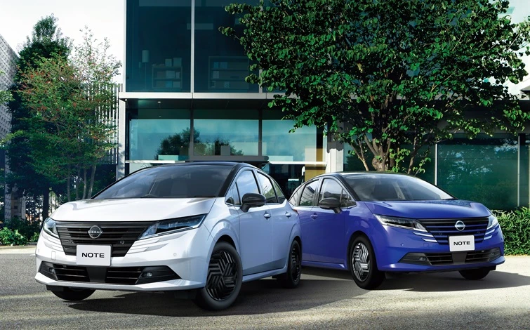 モダンな都市空間を背景に並ぶホワイトとブルーの日産ノート