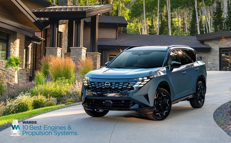 Front left ¾ view of the 2027 Nissan Rogue hybrid parked in front of a house, a Wards 10 best logo is in the bottom left.