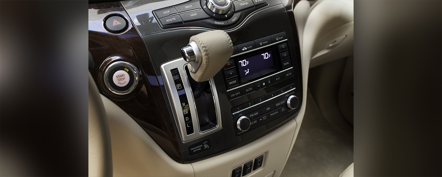 A picture detailing the gear shift with wooden accents of the Nissan Quest.